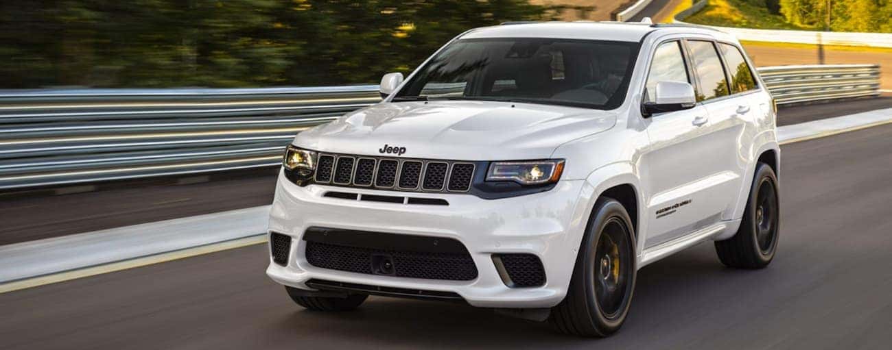 A white 2020 Jeep Grand Cherokee Trackhawk is racing on a track.