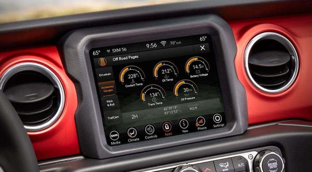 A closeup is shown of the infotainment screen in a red 2020 Jeep Gladiator.