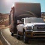 A white 2020 Ram 2500 is towing a large camper after leaving a Ram dealer near me.
