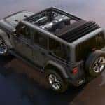 A grey 2019 Jeep Wrangler Unlimited, which is popular among used Jeeps for sale, is shown from above on wet beach sand.