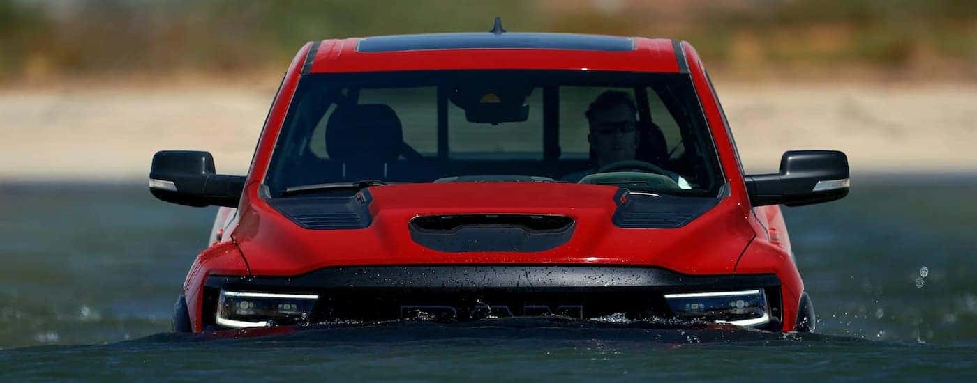 A red 2022 Ram 1500 TRX is shown submerged up to the grille in water.