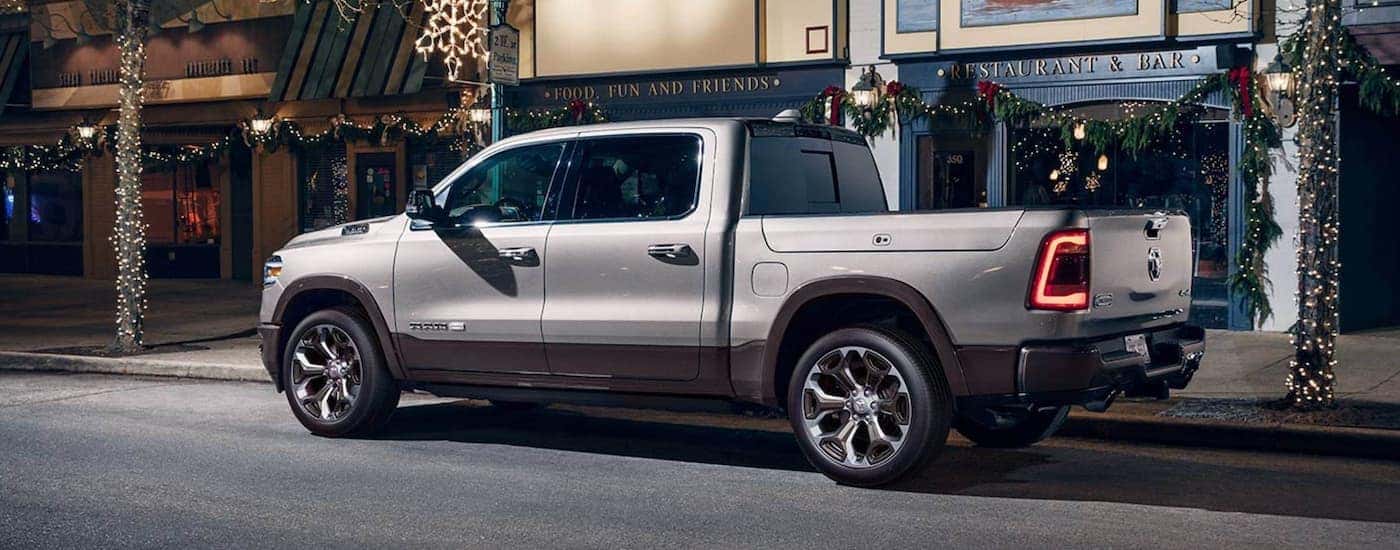 A silver 2020 Ram 1500 Laramie Longhorn is parked on a city street at night.