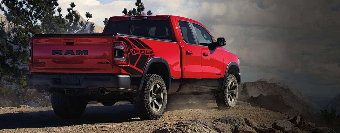 A red 2020 Ram 1500 Rebel is parked on a trail edge with a view.