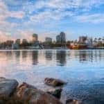 A marina in Long Beach, CA, is shown with city buildings in the distance.
