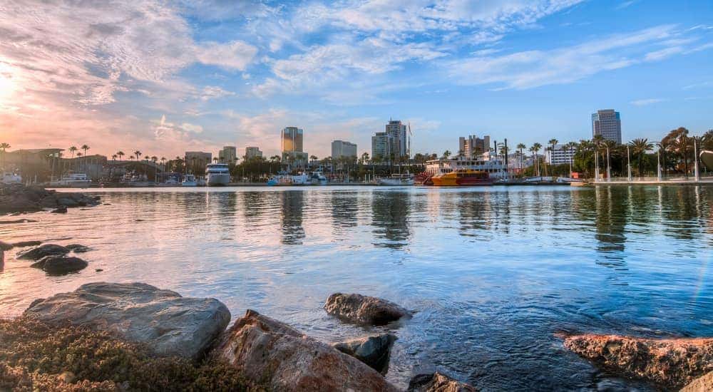 A marina in Long Beach, CA, is shown with city buildings in the distance.