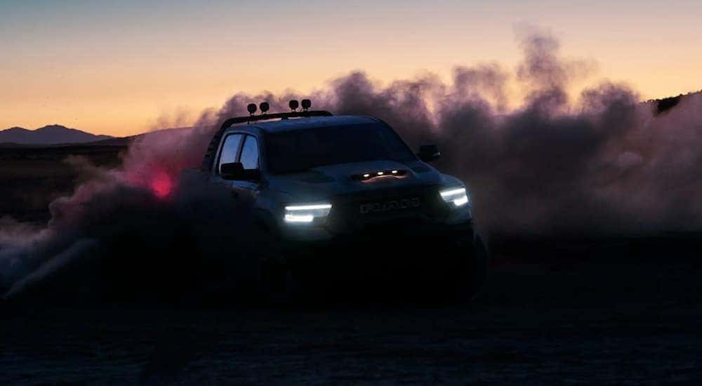 A 2021 Ram 1500 TRX is off-roading at dusk in a desert.