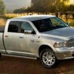 A silver 2017 Ram 1500 is parked on a sunny farm.