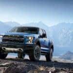 A blue 2017 used Ford F-150-Raptor is parked in the mountains.