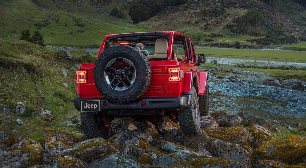 A red 2020 Jeep Wrangler Rubicon is parked on a rocky mountainside shown from behind.