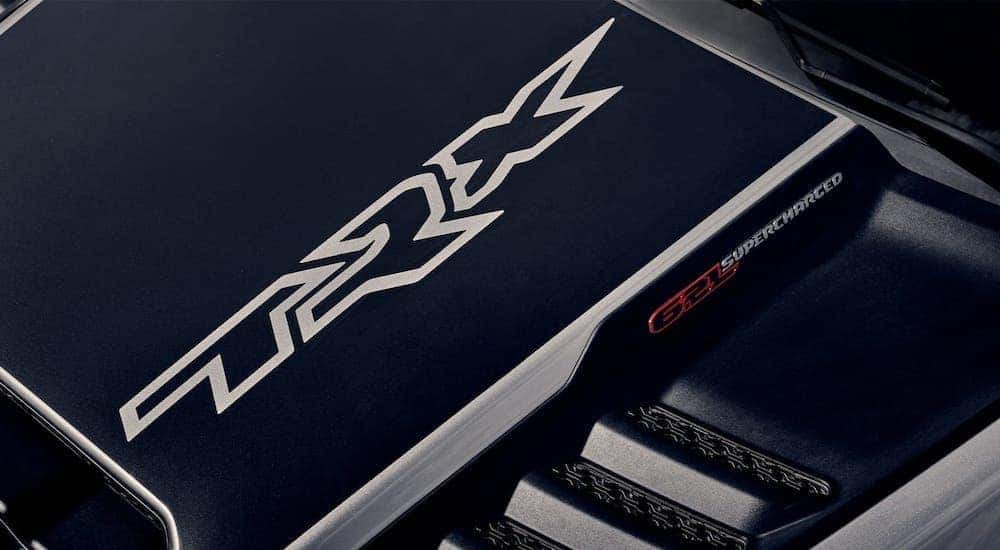 One of the new Ram trucks, a silver 2021 Ram 1500 TRX, is shown with a close up of the hood graphics.