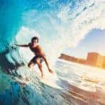 A surfer is under a wave at an Orange County beach.