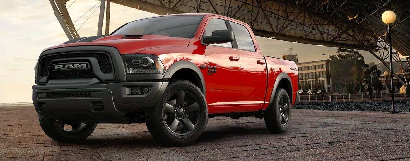 A red 2019 Ram 1500 Classic Warlock is parked in front of a large pavilion.