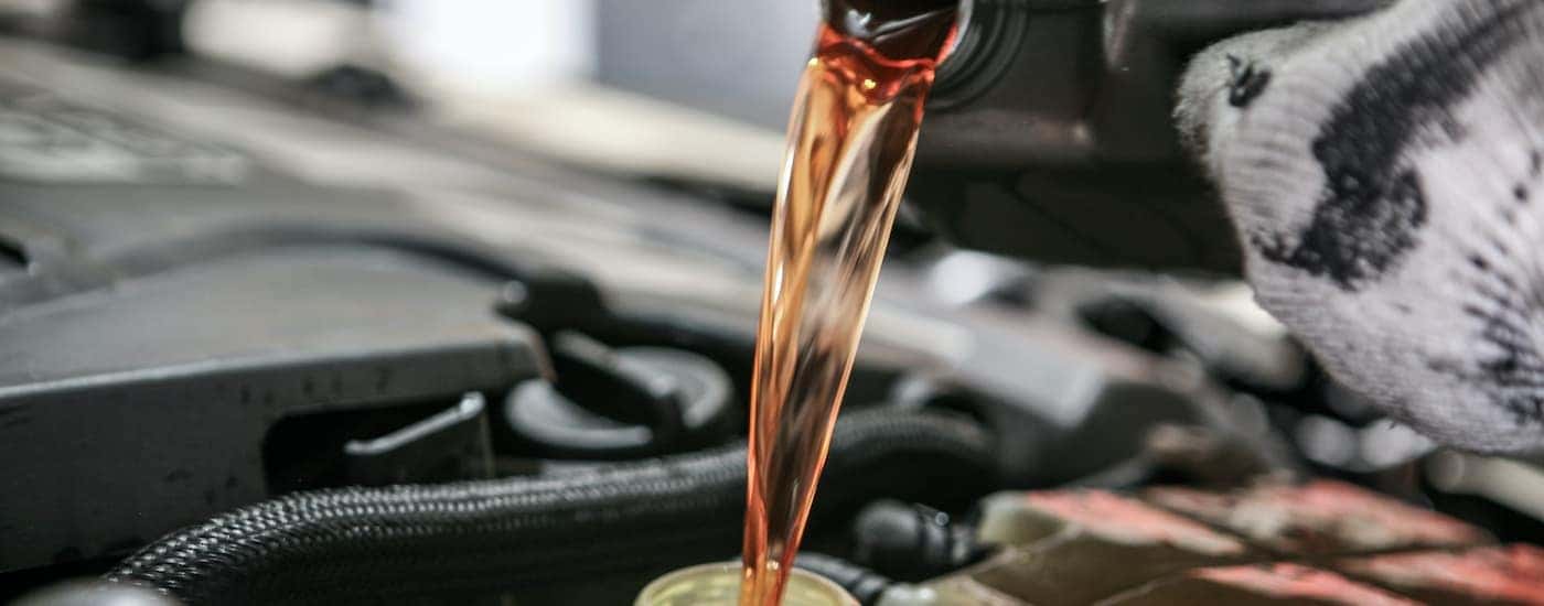 A person is pouring coolant into a vehicle.