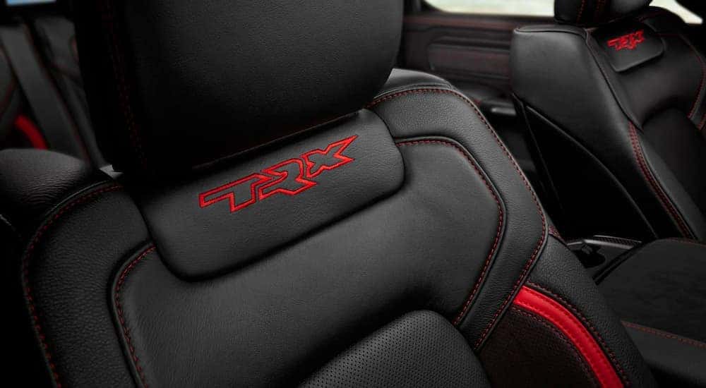 A close up shows the red TRX stitching on the black leather seats of a 2021 Ram TRX.
