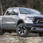A silver 2021 Ram 1500 Rebel is parked on a dirt trail after leaving a Ram 1500 Rebel dealer.