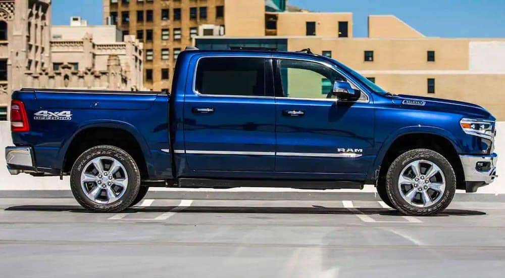 A blue 2019 Ram 1500 is shown from the side parked on a parking structure.