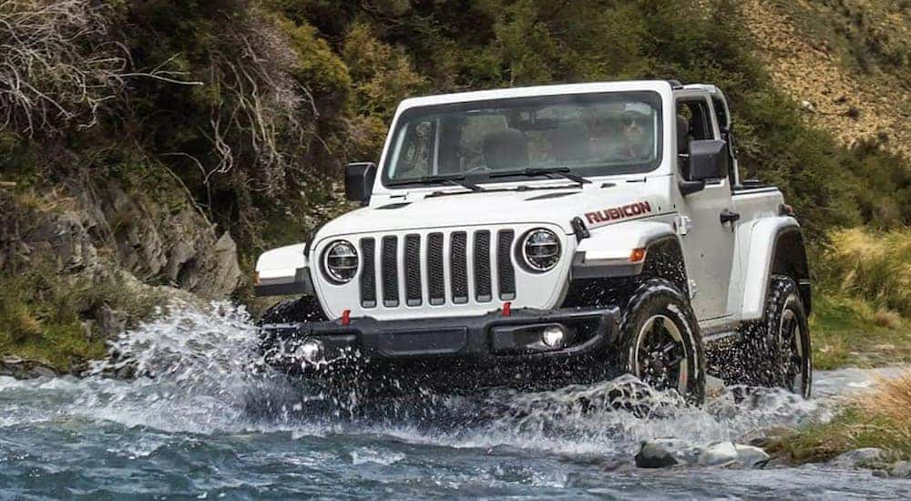 A 2021 Jeep Wrangler Rubicon is driving through a river.