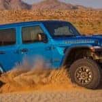 A blue 2021 Jeep Wrangler Rubicon 392 is off-roading in the desert.