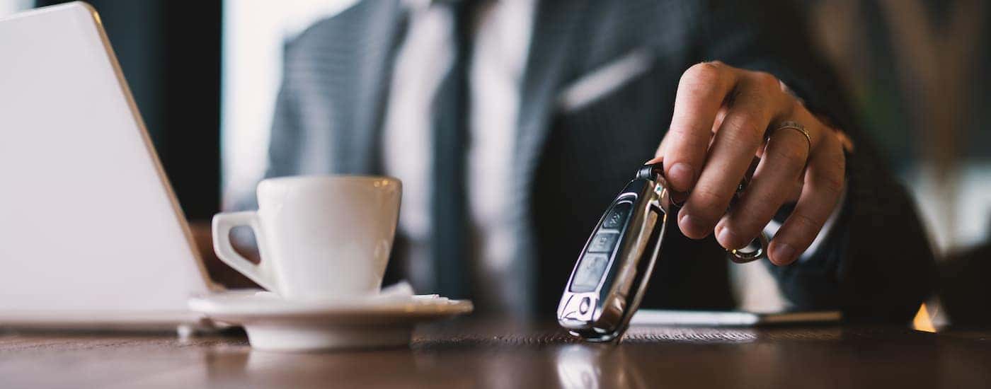 A close up shows a man picking up a set of keys.