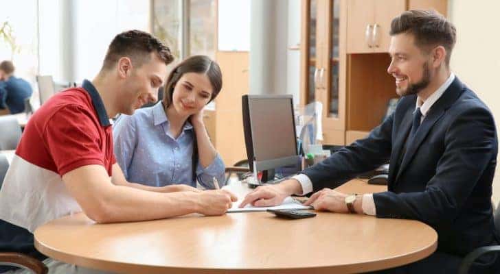 A couple is shown signing paperwork on a Ram lease.