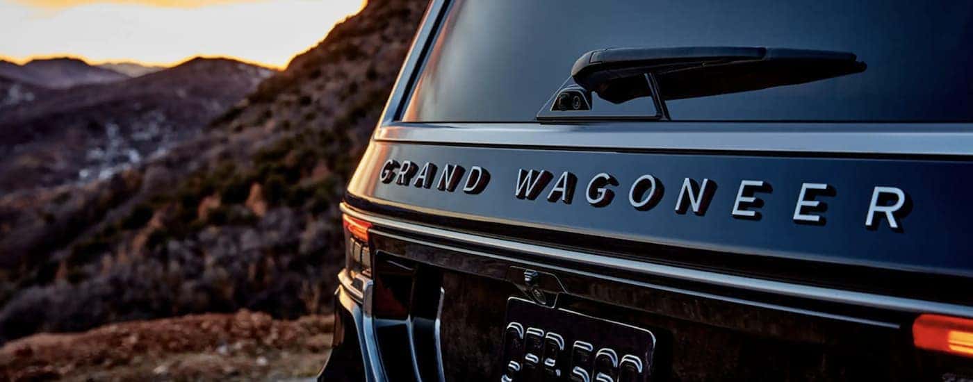A black 2022 Grand Wagoneer shows the logo in close up after leaving a California Wagoneer dealer.
