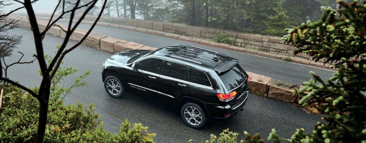 A black 2022 Jeep Grand Cherokee WK is shown driving on a foggy road.
