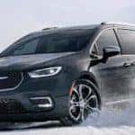 A black 2021 used Chrysler Pacifica is driving through the snow.