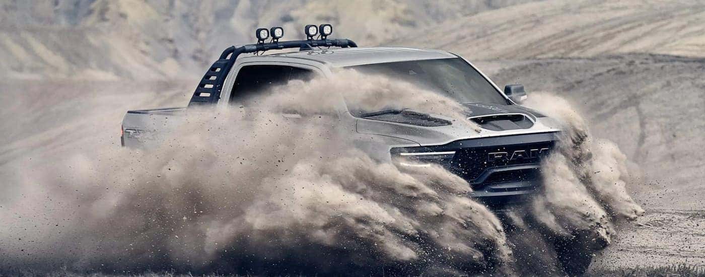 A grey 2021 Ram TRX is driving through the sand.