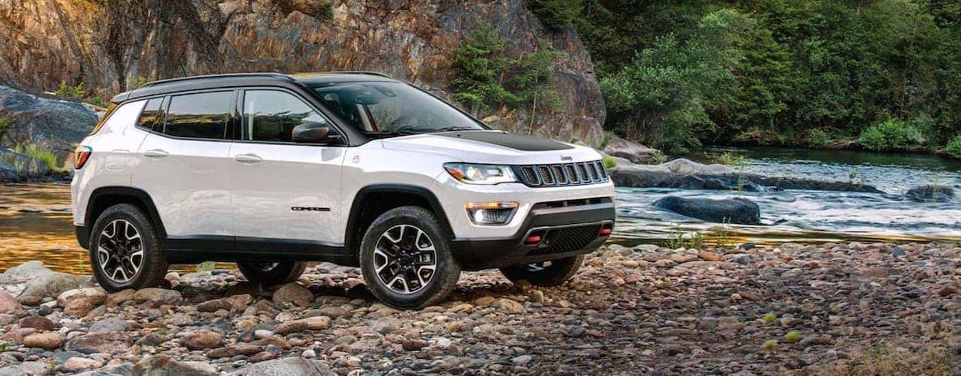 A white 2020 Jeep Compass is shown from the side parked next to a river after leaving a California used Jeep dealer.