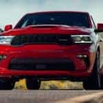 A red 2020 Dodge Durango is shown from the front driving down an empty road.