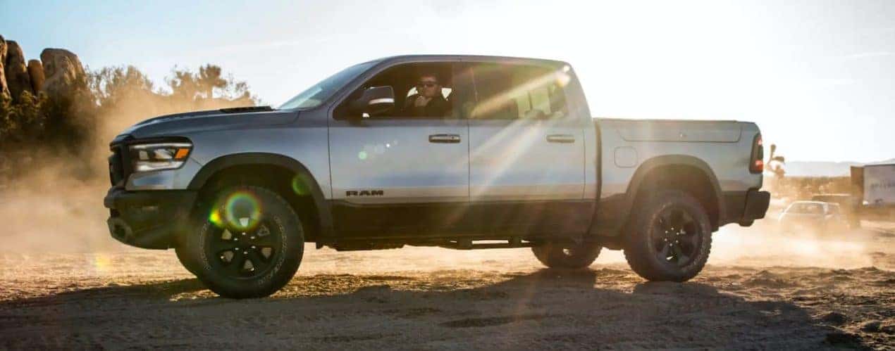 A silver 2021 Ram 1500 Night Edition is shown from the side parked on dirt.
