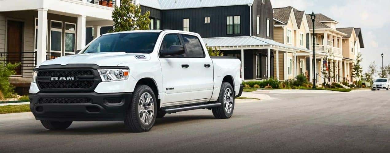 A white 2021 Ram 1500 is shown driving through the suburbs after winning the 2021 Ram 1500 vs 2021 Chevy Silverado 1500 comparison.