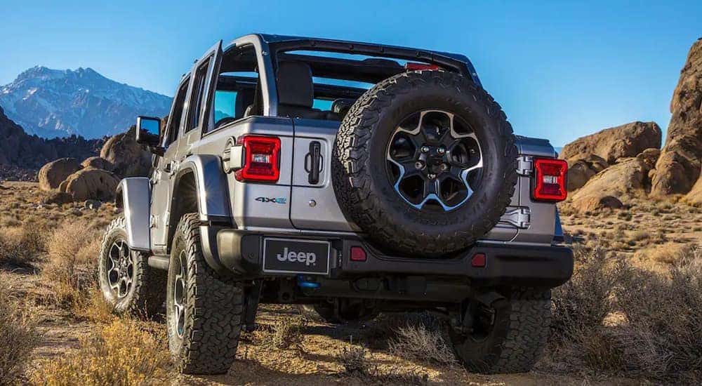 A silver 2021 Jeep Wrangler 4xe is shown off-roading in the desert.