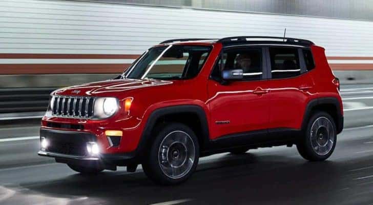 A red 2021 Jeep Renegade is driving through a tunnel.
