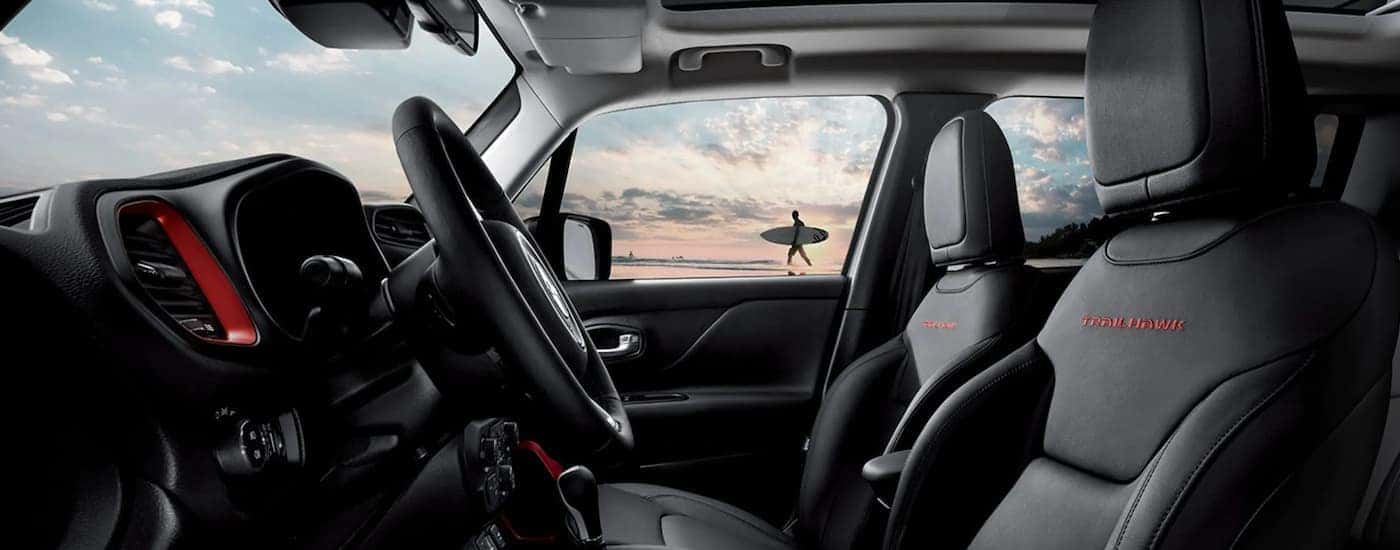 The interior of a 2021 Jeep Renegade shows the steering wheel and infotainment screen.