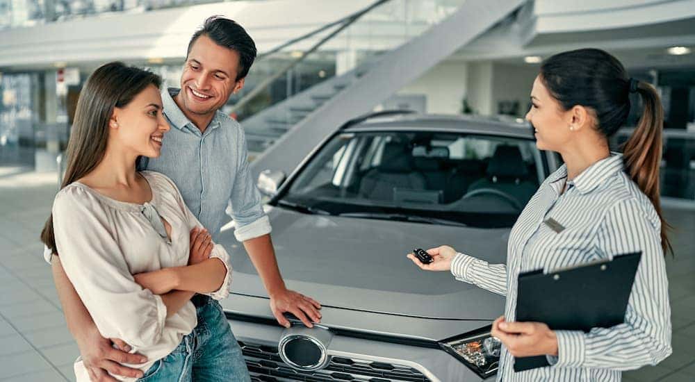 A couple is talking to a salesman about Ram vehicles.