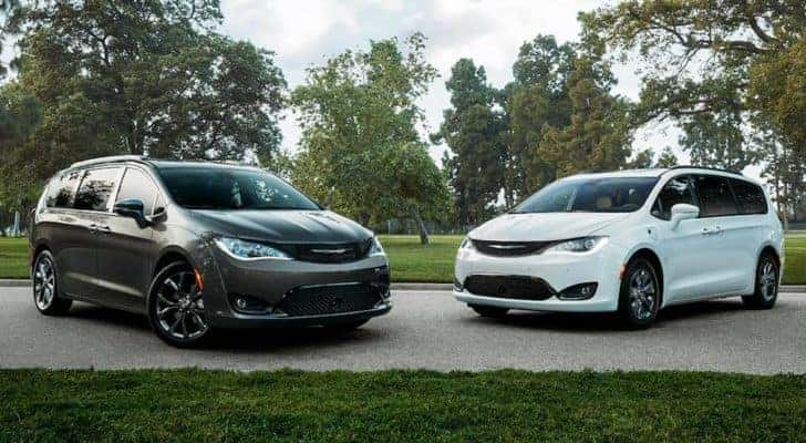 A black and a white 2020 Chrysler Pacifica are parked in front of a field after searching for used cars in Costa Mesa.