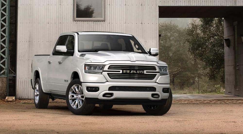 A white 2021 Ram 1500 is parked in front of a barn.