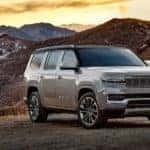 A silver 2022 Grand Wagoneer is shown from the side parked in the mountains after looking at new Jeeps for sale.