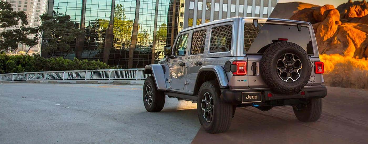 A grey 2021 Jeep Wrangler 4xe is shown from the rear parked on a bridge.