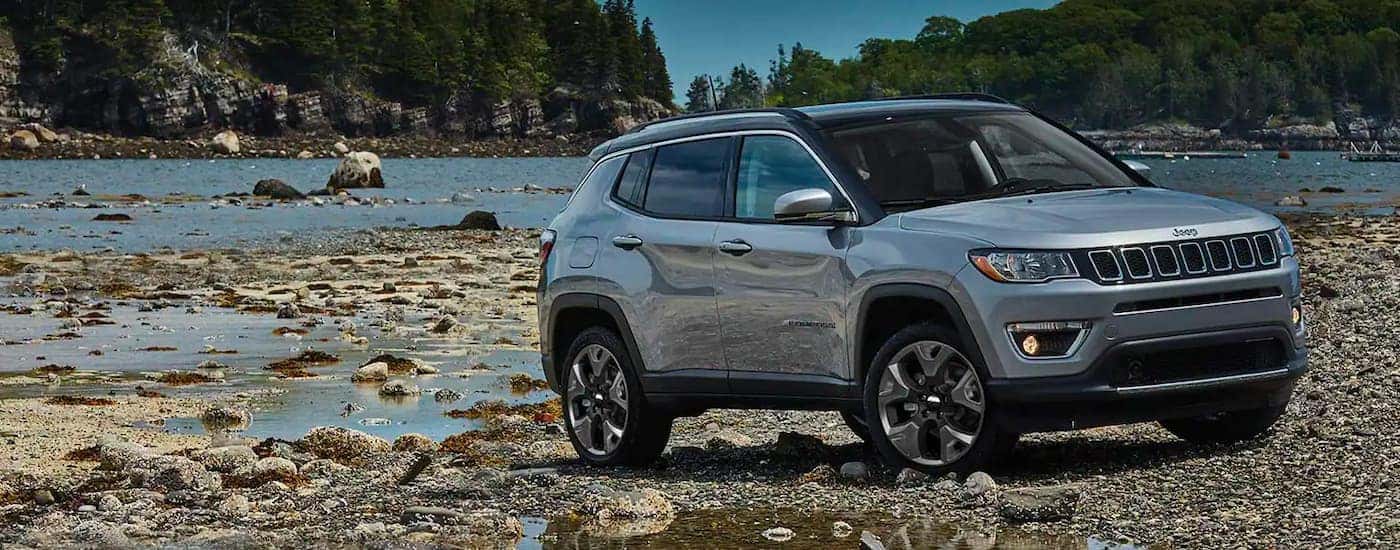 A grey 2020 Jeep Compass is shown on a river bank after researching a used Jeep Compass buyers guide.