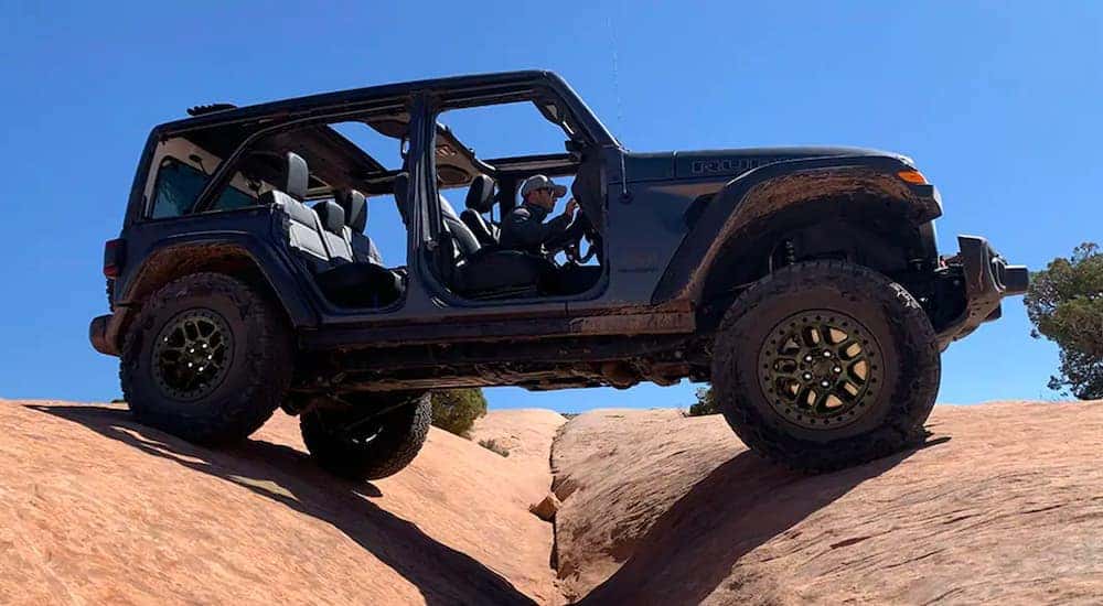 A black 2022 Jeep Wrangler Rubicon Unlimited Xtreme Recon is shown off-roading.