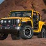 A yellow 2020 Jeep Wrangler Rubicon is shown equipped with multiple accessories a leaving a used Jeep Wrangler dealer.