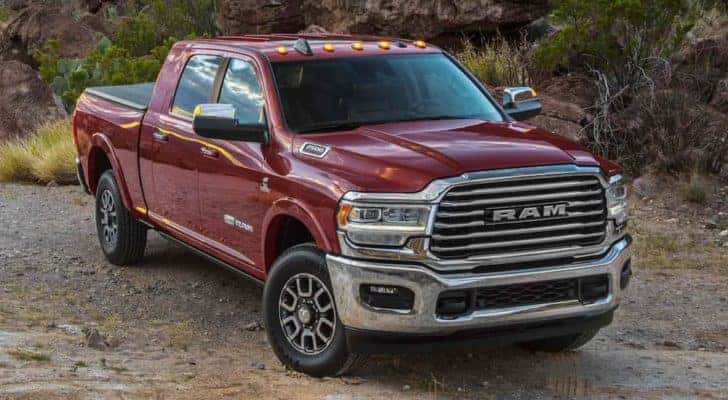 A maroon 2022 Ram 2500 is shown from the front parked in front of forest after leaving a Ram 2500 dealership.