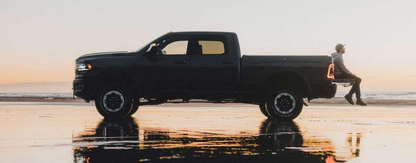 A grey 2022 Ram 2500 is shown from the side parked on the beach at sunset.