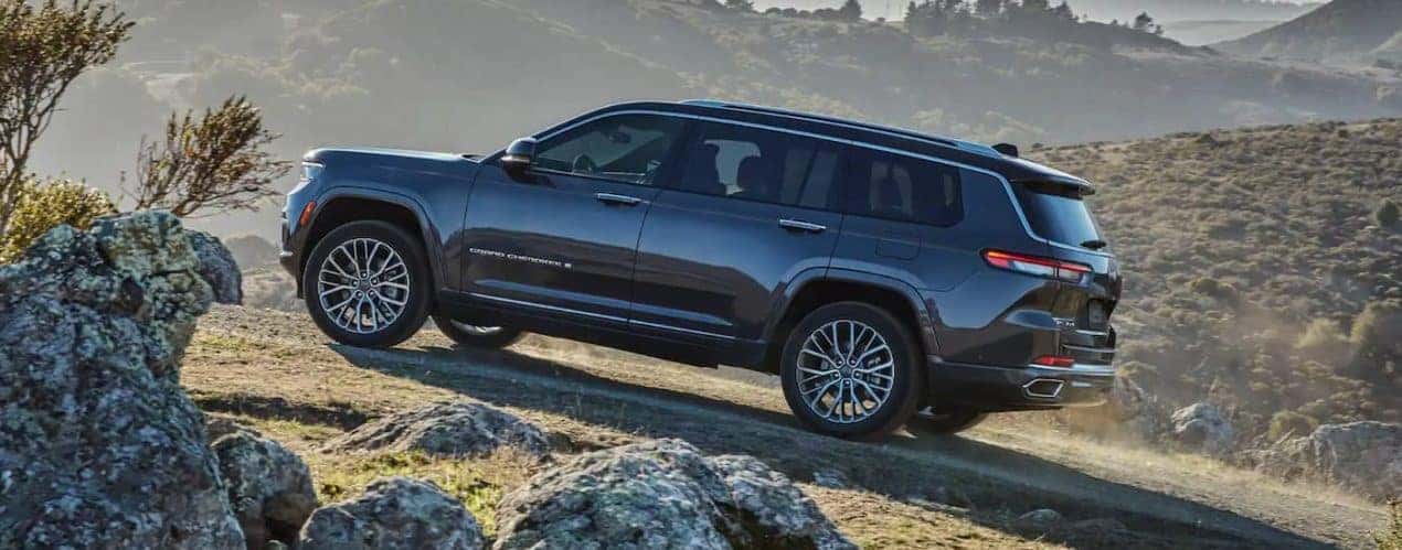 A grey 2022 Jeep Grand Cherokee L is shown climbing a rocky hill after winning a 2022 Jeep Grand Cherokee L vs 2022 GMC Acadia battle.