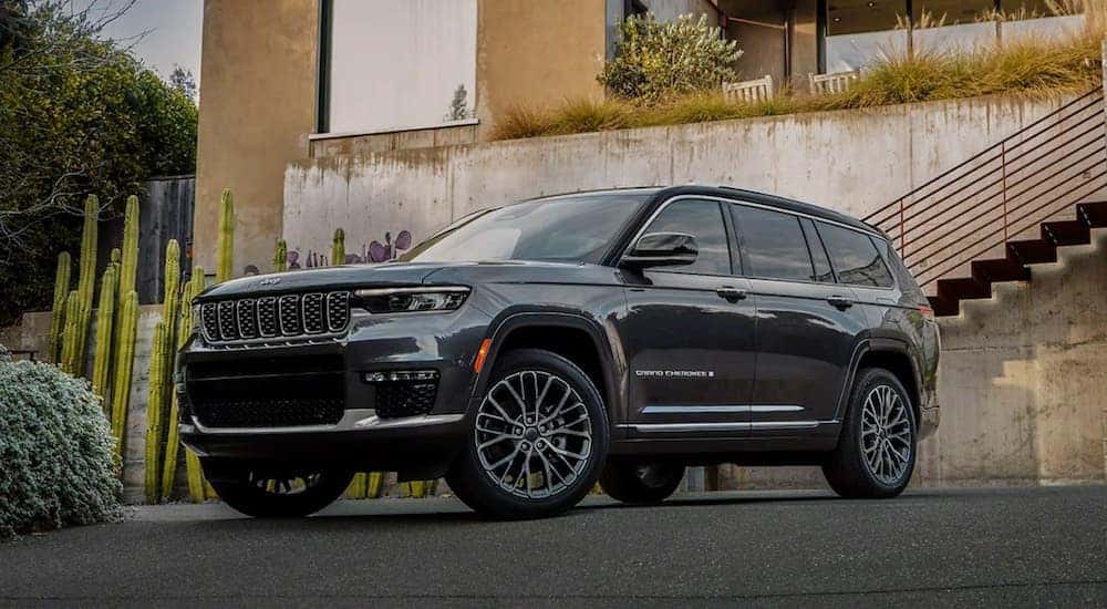 A grey 2022 Jeep Grand Cherokee is shown parked by a concrete wall after leaving a California luxury SUV dealer.