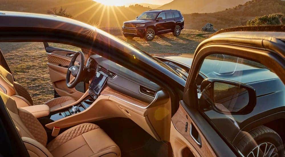 A 2022 Jeep Grand Cherokee is shown with open doors showing off the interior.