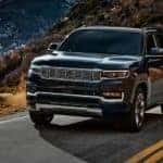 A black 2022 Grand Wagoneer is shown driving on a highway.
