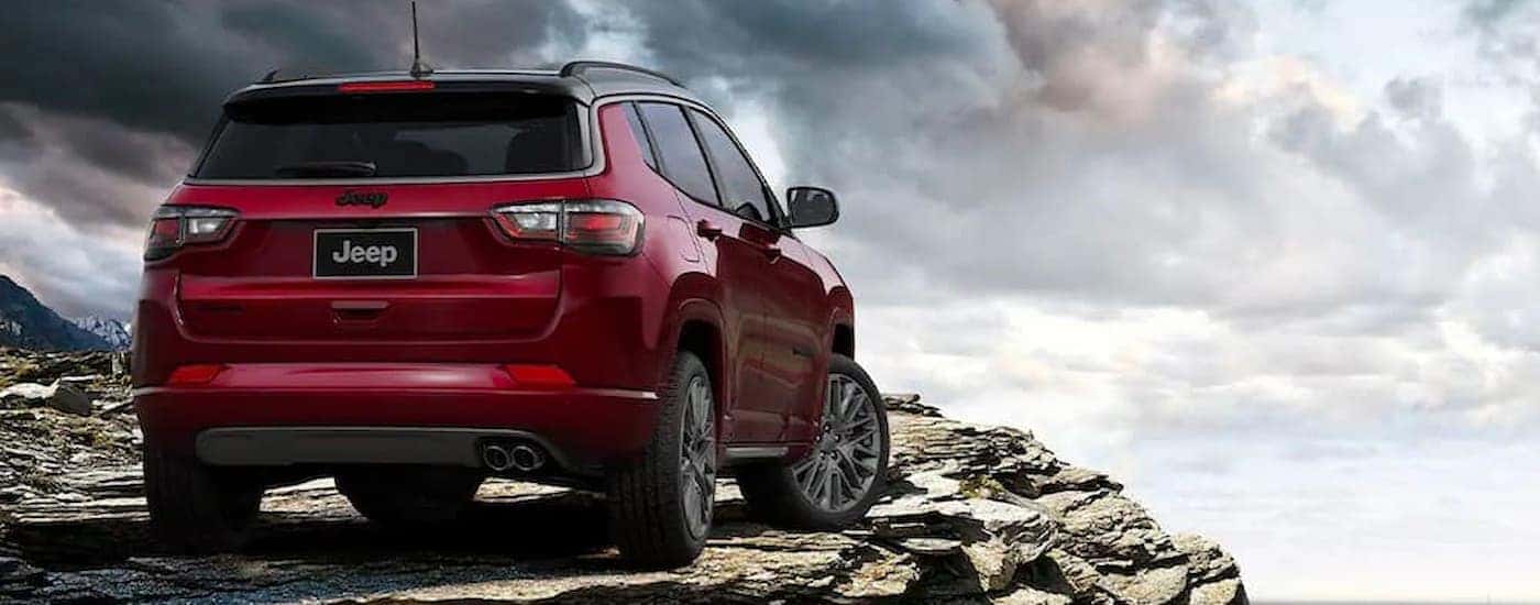 A red 2022 Jeep Compass is shown parked on a rocky cliff.